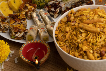 Mix indian sweets like kaju roll dryfruits barfi mango peda served in a plate