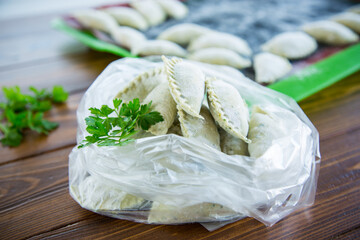 Raw green dough dumplings with parsley, dill.