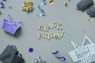 Black friday text with gifts, shopping baskets and festive tinsel flat lay. Black friday sale...