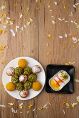 plate full of assorted laddoos like motichur laddoo, bundi ladu and pistchio laddu with farsan or namkin