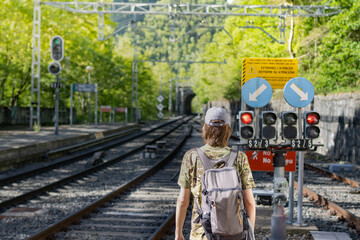 Man in camouflage clothing and cap at the train station waiting for the train in Ribes de Freser, Catalonia (Spain).