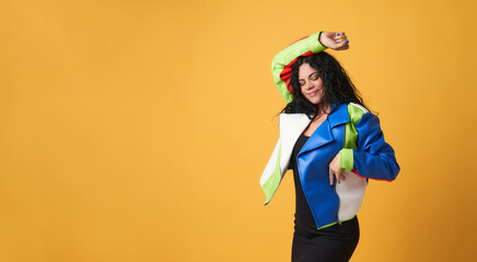 portrait of funny smiling woman dancing isolated on yellow background with space for copi