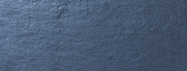 Navy blue background of natural slate. Texture of rough dark cool gray stone backdrop, closeup.