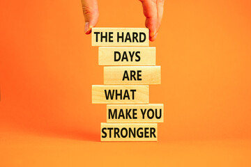 Support and be stronger symbol. Concept words The hard days are what make you stronger on wooden blocks. Bussinesman hand. Beautiful orange background. Business and be stronger concept. Copy space.