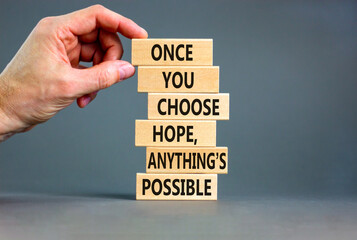 Hope and anything is possible symbol. Concept words Once you choose hope anything is possible on wooden blocks on a beautiful grey background. Businessman hand. Business and hope concept. Copy space.