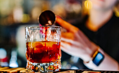 woman hand bartender making negroni cocktail in bar