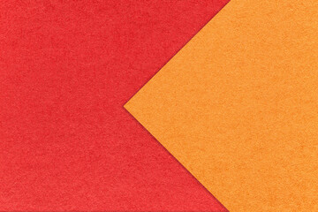 Texture of red paper background, half two colors with orange arrow, macro. Structure of craft...