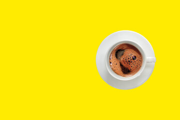 A cup of foamy Turkish coffee on a yellow background