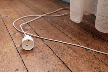 authentic electrical extension cord lies on an old vintage wooden floor