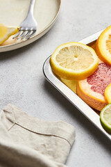 Top view of sliced ​​citrus on a tray. Orange, grapefruit, lemon and lime showcasing healthy food in a flat lay. Natural beauty, medical concept of cliced fruits.