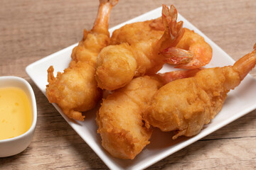 Battered shrimp with plum sauce in white plate
