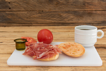 Desayuno español de café y mollete con jamón, aceite y tomate frotado, fondo rústico - obrazy, fototapety, plakaty