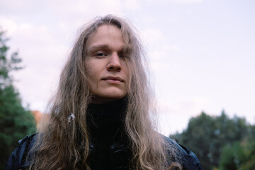 Portrait of young model man with long blond hair