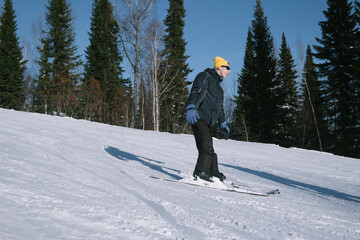 Portrait of happy young man living with a chronic health condition, skiing in ski resort. Winter sport outdoor