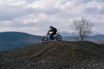 motorcyclist riding off-road dirt motorcycle on gravel hills © Annatamila