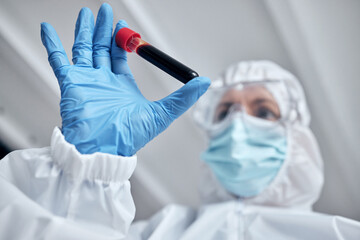Doctor, hands and blood tube for covid test or science research, experiment or results at the...