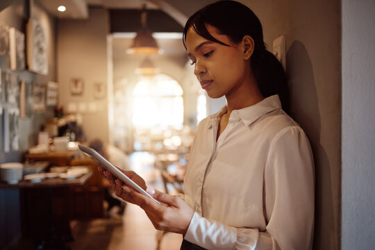 Small business cafe, tablet planning and restaurant manager check online inventory, food menu products or catering service. Waitress worker, coffee shop digital app management or hospitality industry