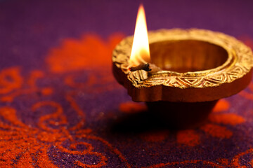 Happy Diwali Festival of Lights violet color background with golden color traditional clay oil lamp...