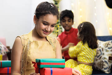 Young girl, kid, dressed up in ethnic wear excited with the gift and expression celebrating diwali Hindu festival Laxmi poojan