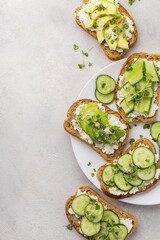 Vegetarian green sandwiches with avocado and cucumber with microgreens on a light background