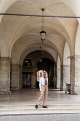 Smiling african american woman posing near old building on urban street in Treviso.