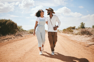 Love, couple and summer with a black woman and man walking on a sand road in the dessert while on vacation. Romance, dating and holiday with a young male and female on a walk together in nature