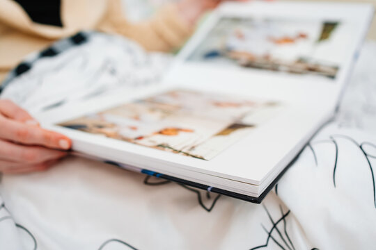 Selective focus and blurry photos. a woman holds a photo book.