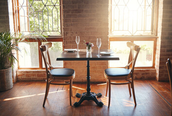 Empty room, glasses and table at a restaurant for a romantic date, celebration or luxury dinner. Wineglass for champagne, wine or alcohol beverage for a banquet, romance meal or elegant event.