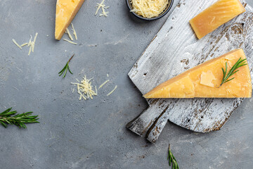 Parmesan cheese with rosemary on a gray table, banner, menu, recipe place for text, top view