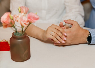 Close-up diamond ring proposal couple holding hands