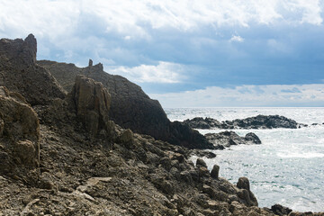 ocean shore with rocks of columnar basalt, Cape Stolbchaty on Kunashir Island