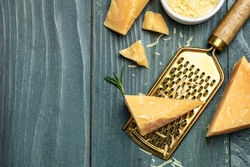 Parmesan cheese with metal grater on a wooden board, place for text, top view