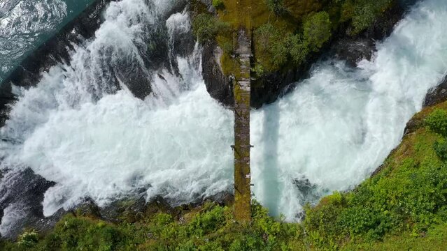 wooden bridge across Lake Lovatnet with a glacial river, view from above. moving aerial