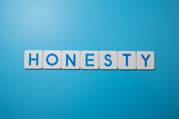 Word HONESTY on blue background,business concept. Beautiful blue background.Close up