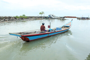A fishing boat cruises in the water, this boat is used as a fishing boat by local Indonesian fishermen. The fishing boat goes to sea