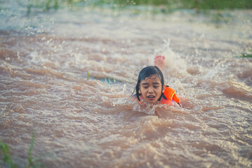Children playing water of flooding in countryside