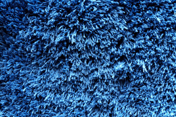 Fuzzy blue for plaid. Shaggy blanket background. Fluffy fake textile fur. Selective focus