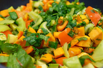 Cooking vegetable stew with peppers, carrots, zucchini and celery. Shuffles in close-up. Homemade Veggie food