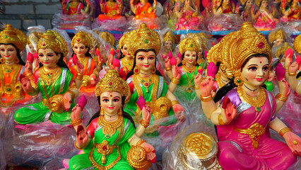 Beautiful statues of godess Lakshmi newly made in different style displayed for sale during festival of Diwali. Handcrafted Laxmi idols for Diwali celebration are ready to sell.