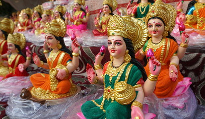 Beautiful statues of godess Lakshmi newly made in different style displayed for sale during festival of Diwali. Handcrafted Laxmi idols for Diwali celebration are ready to sell.