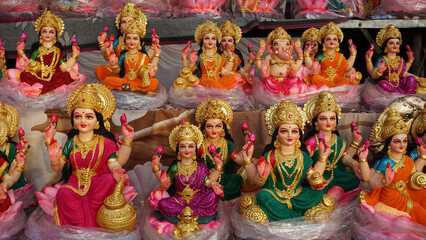 Beautiful statues of godess Lakshmi newly made in different style displayed for sale during festival of Diwali. Handcrafted Laxmi idols for Diwali celebration are ready to sell.