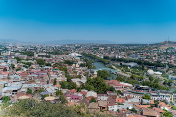 Fototapeta na wymiar Tbilisi, Georgia - October 1 2022: Beautiful panoramic aerial view of Tbilisi at sunset