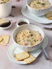 Camembert white sauce with Colorful penne pasta in a white bowl with fresh chives and crackers, side  view