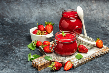 Jar of strawberry jam . Homemade strawberry marmelade and fruits on wooden board. Long banner format
