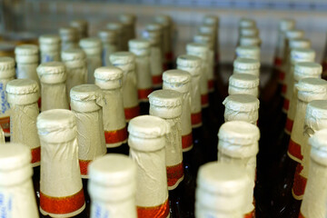 Lots of beer beer bottles background texture. Sale of alcohol in a hypermarket. Selective focus