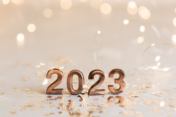 Holiday background Happy New Year 2023. Numbers of year 2023 made by gold candles on bokeh festive...