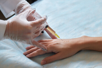 Doctor doing stem cell therapy on a patient's elbow after the injury. Treating knee pain with...