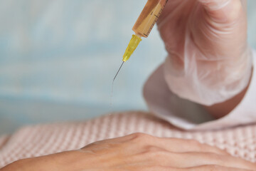 Doctor doing stem cell therapy on a patient's elbow after the injury. Treating knee pain with...