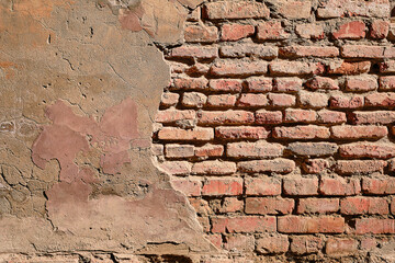 Wall of an old house with bricks and plaster, background for advertising or wallpaper about renovation. Old wall background