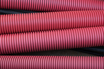 red corrugated pipe are buried underground on the street. underground electric cable infrastructure...